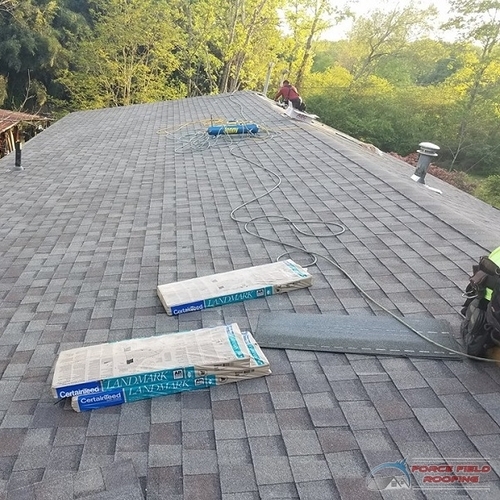 work being done on an asphalt shingle roof